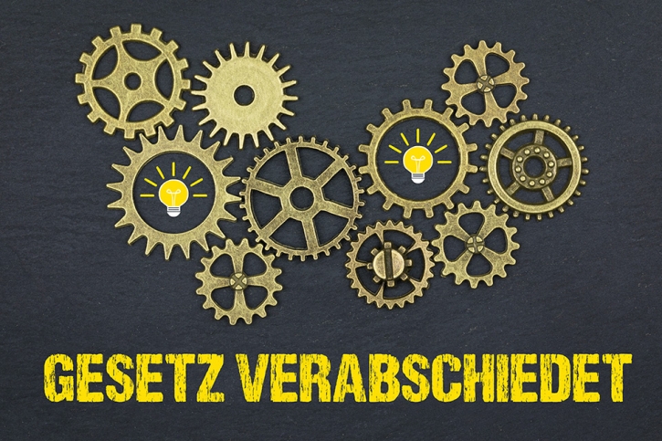 Foto: Zahnräder über Schriftzug GESETZ VERABSCHIEDET